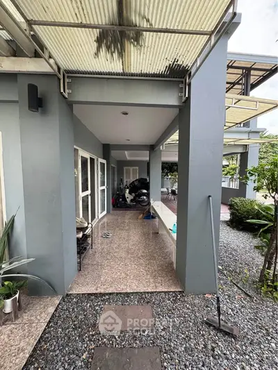 Modern home exterior with covered walkway and garden view