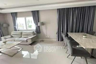 Modern living room with sleek furniture and elegant dining area, featuring large windows and stylish decor.