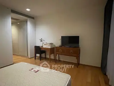 Spacious bedroom with wooden flooring and modern furniture