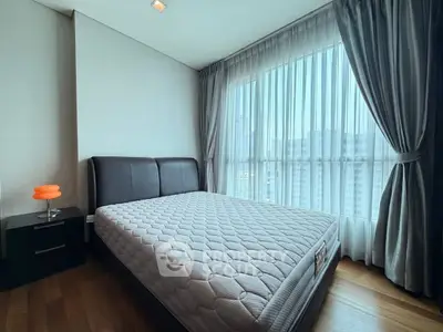 Modern bedroom with large window and stylish curtains in a high-rise apartment.