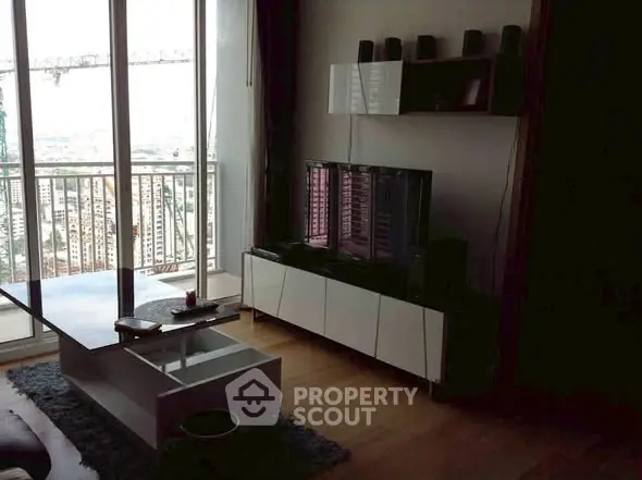 Modern living room with balcony view, sleek furniture, and entertainment setup.