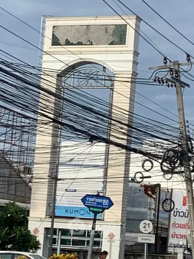 Commercial building exterior with signage and power lines in urban setting.