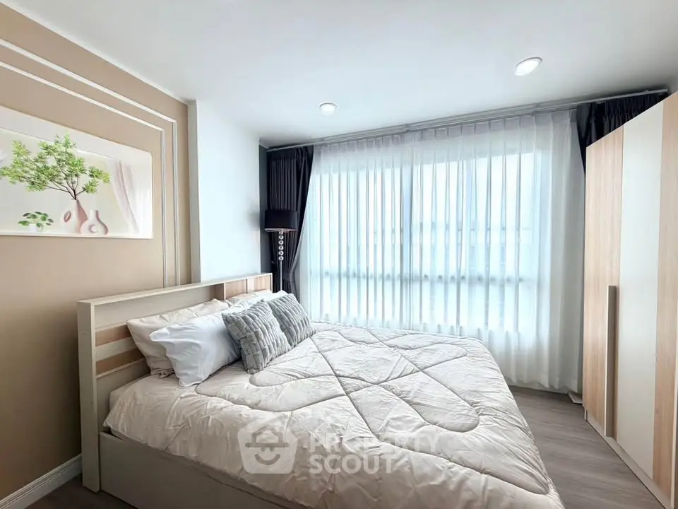 Bright and cozy bedroom with modern decor and large window for natural light.