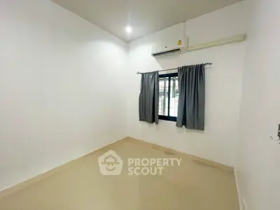 Spacious unfurnished room with air conditioning and window view, ideal for customization.