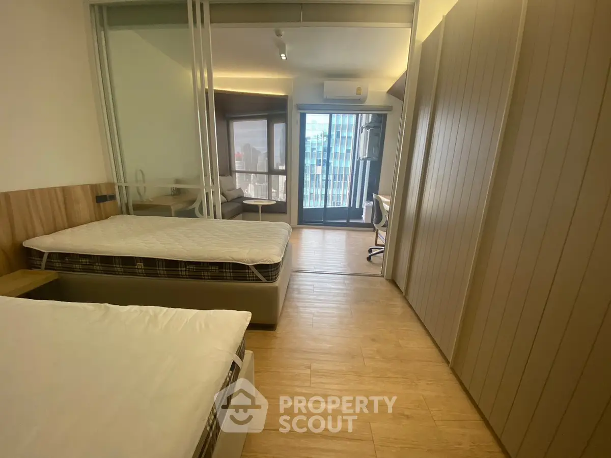 Modern bedroom with twin beds and balcony view in urban apartment