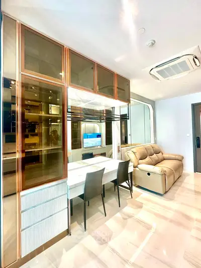 Modern living room with sleek furniture and built-in storage, featuring a cozy sofa and elegant dining area.