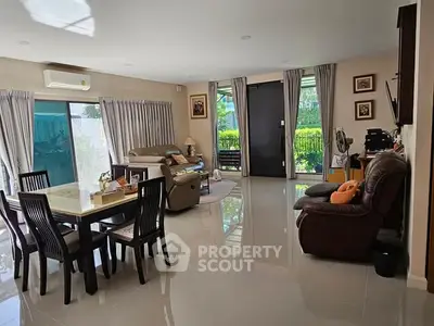 Spacious living room with modern decor and garden view, perfect for family gatherings.