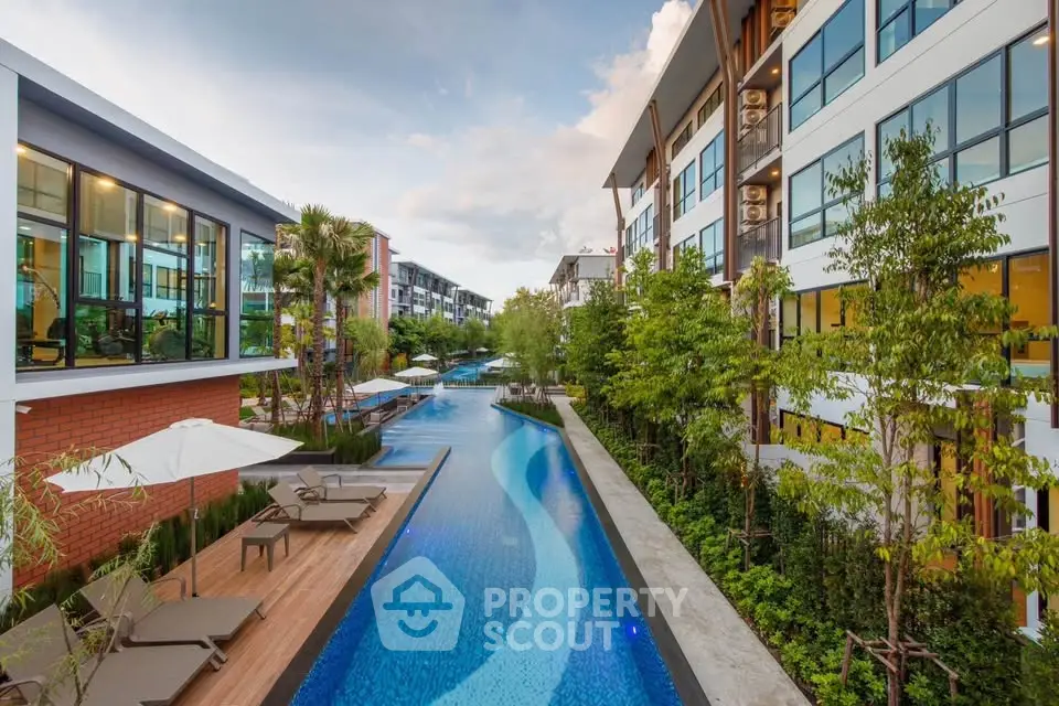 Luxurious modern apartment complex with stunning pool and lush greenery.