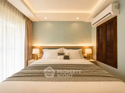 Luxurious bedroom with elegant lighting and cozy bedding in modern apartment.
