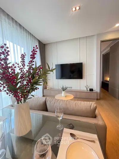 Modern living room with elegant decor, large TV, and stylish dining setup in a luxurious apartment.