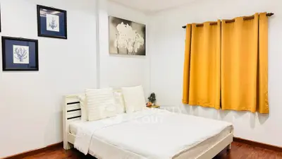 Cozy bedroom with elegant decor and warm lighting, featuring a comfortable bed and stylish artwork.