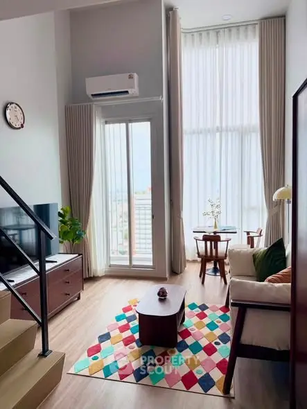 Chic modern living room with high ceilings, large windows, and colorful decor in a stylish apartment.