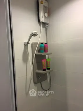 Modern bathroom shower with sleek white tiles and mounted showerhead