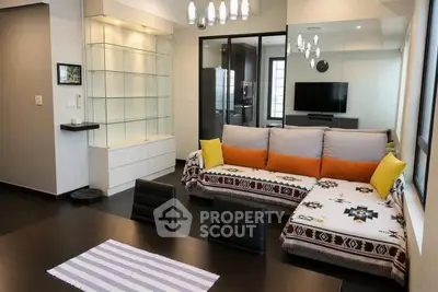 Modern living room with stylish decor and open layout, featuring a cozy sectional sofa and elegant lighting.