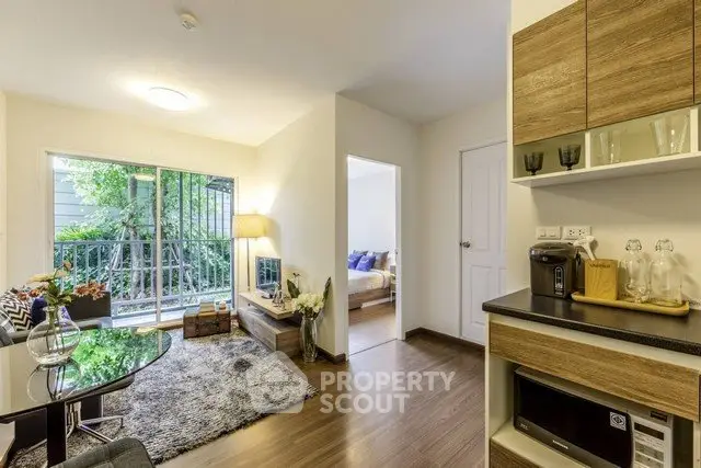 Modern living room with cozy decor and natural light, featuring a view of the garden through large windows.
