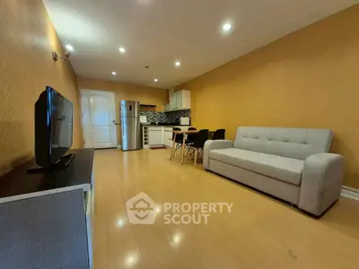 Spacious living room with modern kitchen and cozy seating area in open layout apartment.