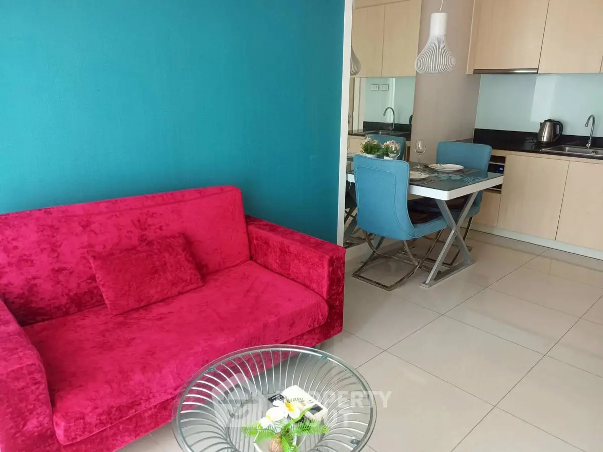 Modern living room with vibrant red sofa and stylish kitchen area