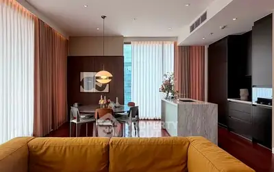 Luxurious modern living room with open kitchen and elegant dining area, featuring floor-to-ceiling windows.