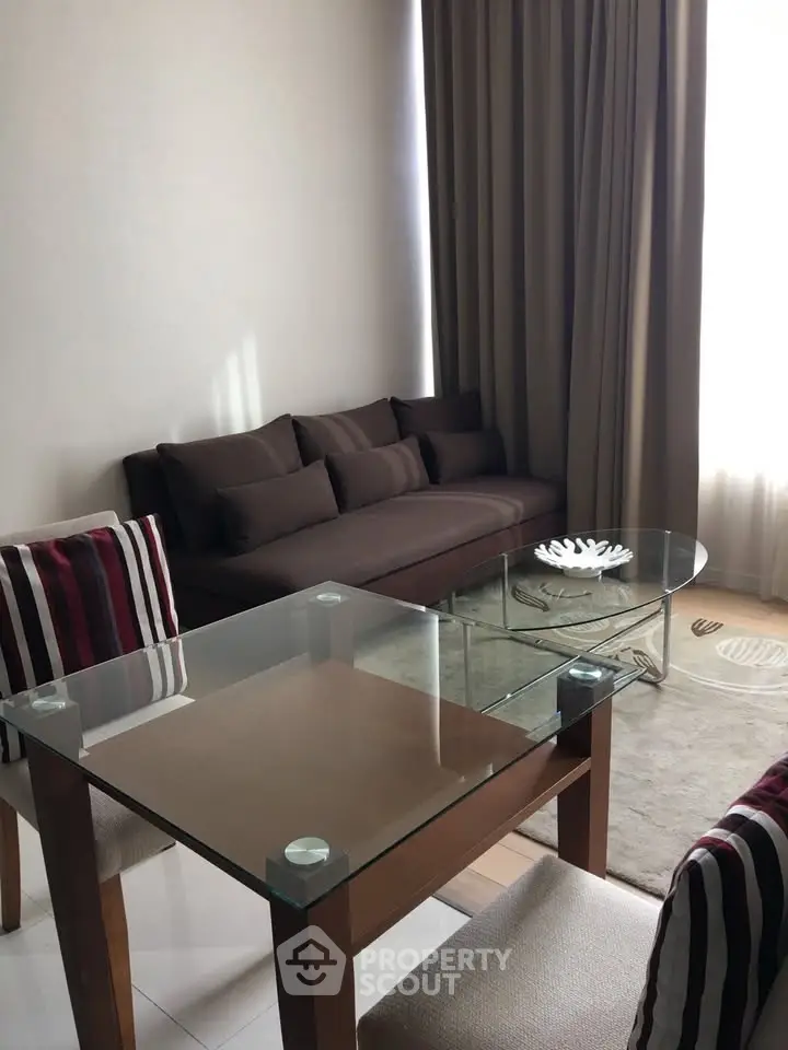 Modern living room with glass table and cozy brown sofa, perfect for relaxation and entertaining.
