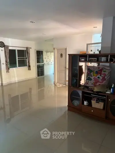 Spacious living room with glossy tiled floors and natural light