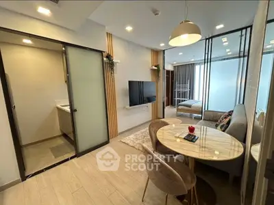 Modern living room with stylish decor and open layout, featuring a cozy dining area and sleek TV setup.