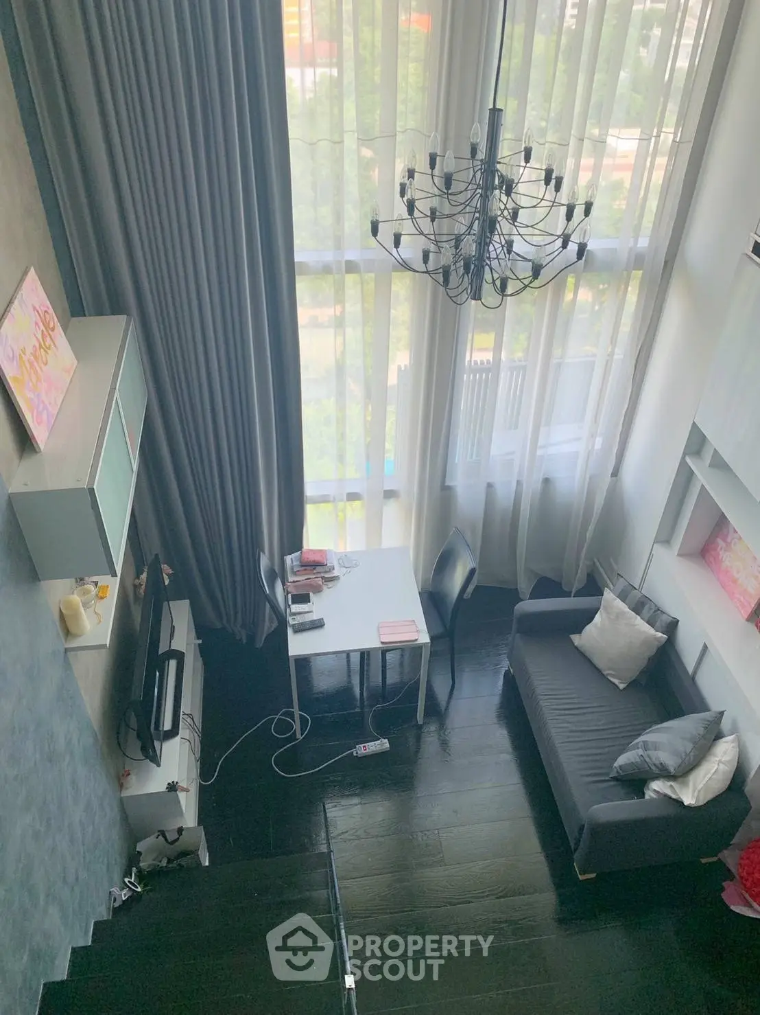 Stunning loft-style living room with high ceilings and large windows offering a bright and airy atmosphere.