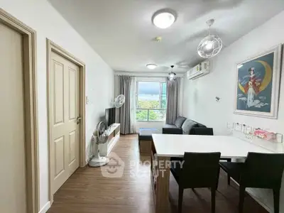 Modern living room with dining area, stylish decor, and natural light.