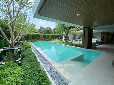 Luxurious outdoor pool with lush greenery and modern design, perfect for relaxation and entertainment.