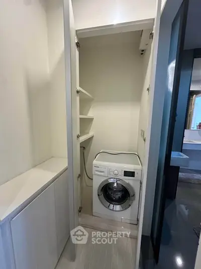 Compact laundry area with modern washing machine in sleek apartment