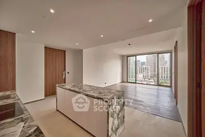 Luxurious open-plan living room with stunning city view and modern marble kitchen island.