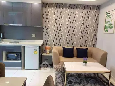 Modern open-layout kitchen and living area with stylish decor and compact appliances.
