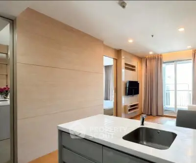 Modern open-plan living room with sleek kitchen island and balcony access