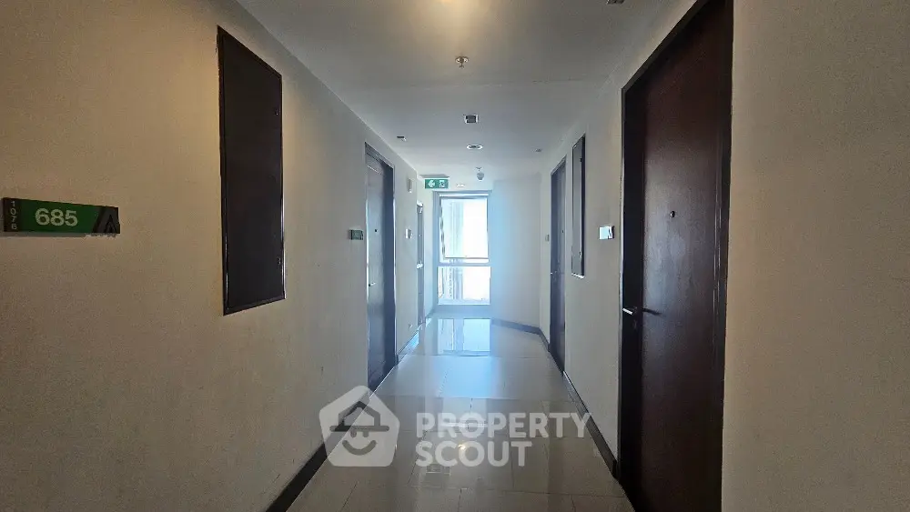 Modern apartment hallway with glossy floors and numbered doors