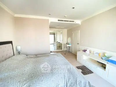 Spacious bedroom with modern decor and ample natural light, featuring a cozy bed and stylish furnishings.