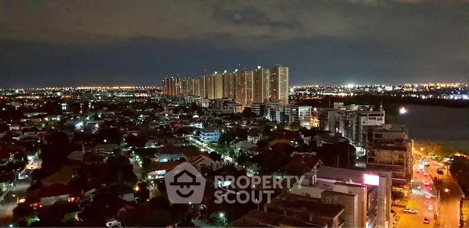 Stunning nighttime cityscape view with illuminated skyline and residential area.