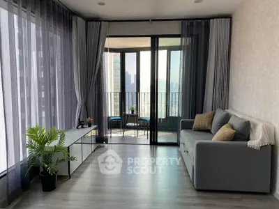 Modern living room with floor-to-ceiling windows and balcony view in urban apartment.