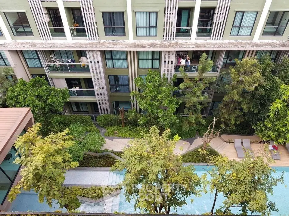 Modern apartment building with lush garden and swimming pool view