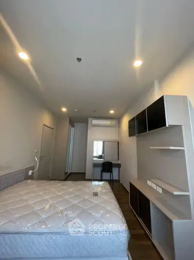 Modern bedroom with sleek furniture and ample lighting, perfect for a cozy living experience.