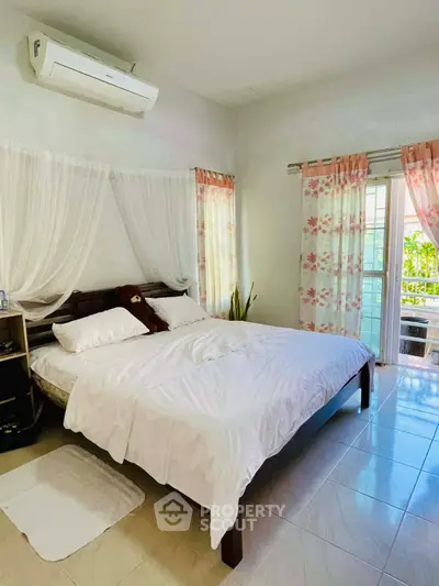 Spacious bedroom with elegant decor and balcony access, featuring a cozy bed and air conditioning.
