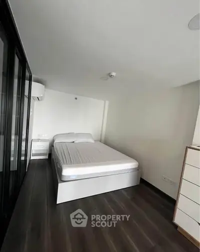 Modern minimalist bedroom with sleek design and ample natural light.