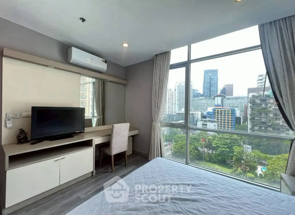 Modern bedroom with city view, large window, and stylish decor in urban apartment.