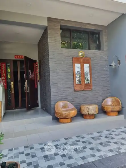 Charming modern entrance with unique wooden seating and stone facade