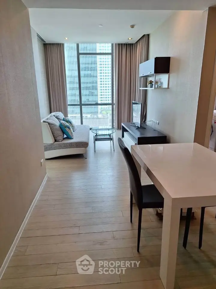 Modern living room with floor-to-ceiling windows and stylish decor in a high-rise apartment.