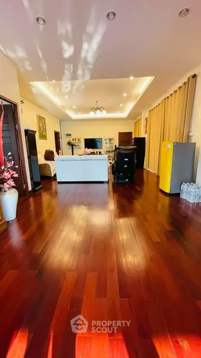 Spacious living room with elegant hardwood floors and modern lighting