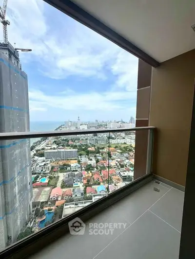Stunning high-rise balcony with panoramic city and ocean views, perfect for urban living.