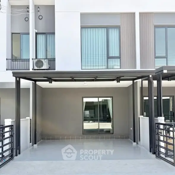 Modern townhouse exterior with sleek design and spacious carport area.