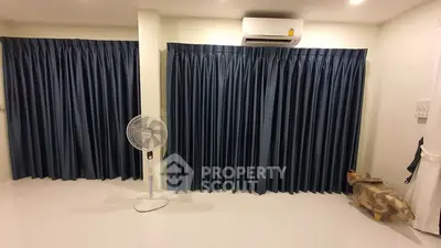 Spacious room with dark blue curtains and air conditioning unit