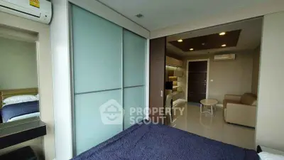 Modern bedroom with sliding glass closet doors and cozy seating area