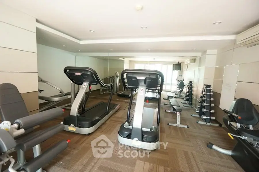 Spacious gym with modern equipment in luxury apartment complex