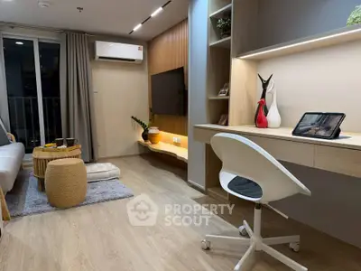 Modern living room with stylish decor, featuring a cozy seating area, sleek desk, and balcony access.